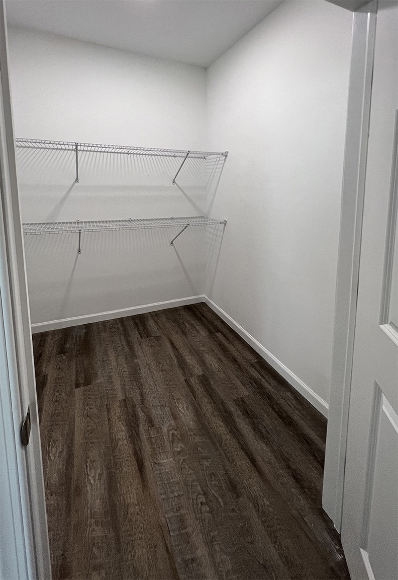 an empty room with white walls and wood floors