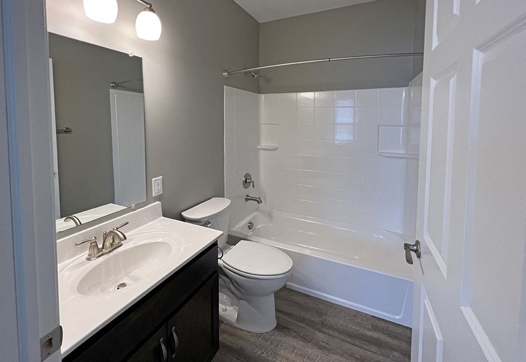 a bathroom with a toilet and a tub and a sink