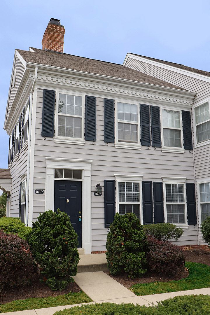 a white house with black shutters and a blue door