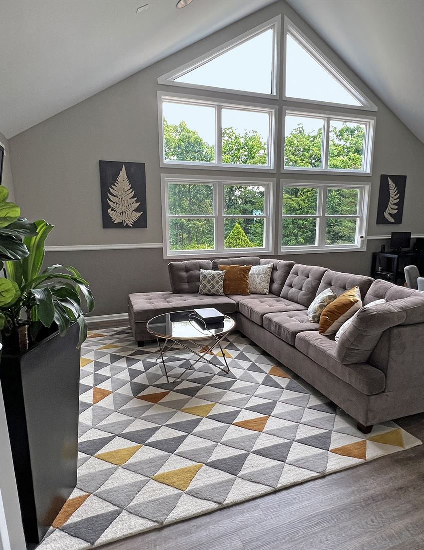 a living room with a large window and a large couch