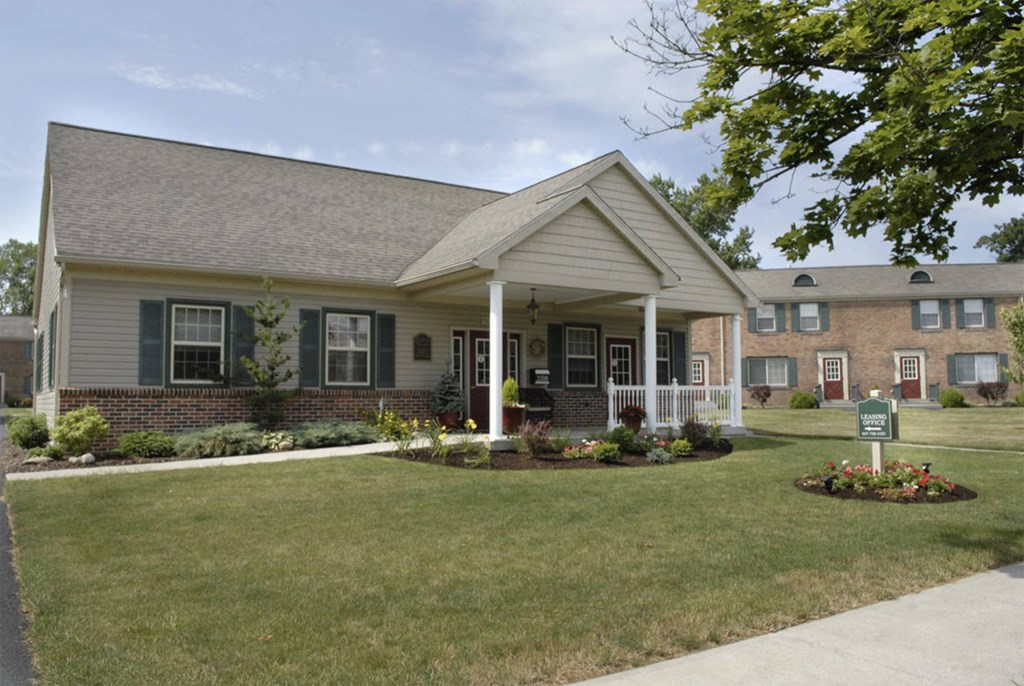 the front of a house with a lawn and a porch