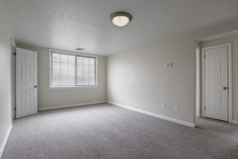 the living room of an empty house with a window and a door