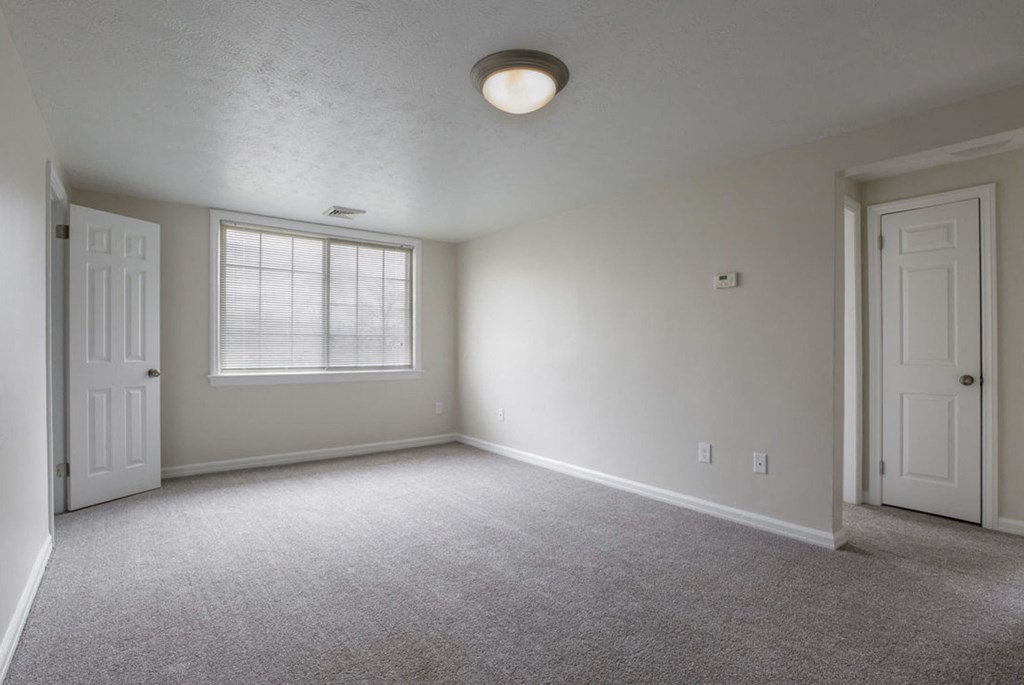 the living room of an empty house with a window and a door