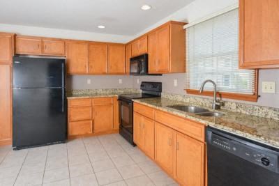 a kitchen with wooden cabinets and a black refrigerator