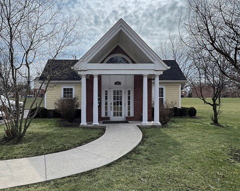 A house with a front porch and a walkway leading to the front door.