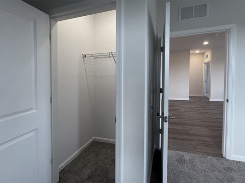 a bedroom with a closet and a hallway with a door open