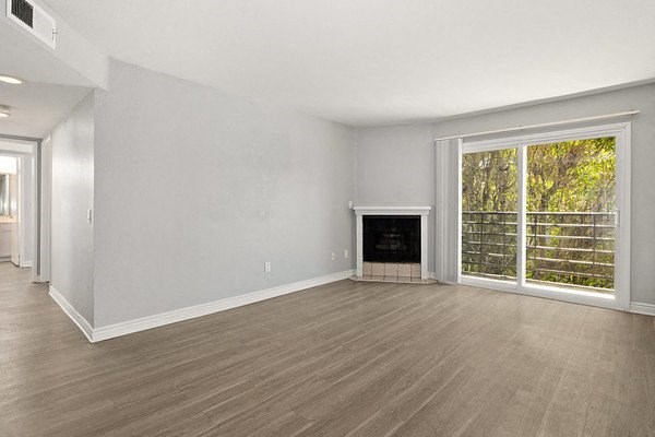 an empty living room with a fireplace and a large window
