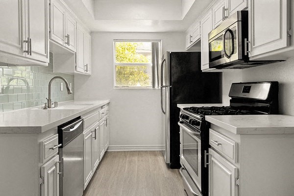 a white kitchen with a stove and a microwave