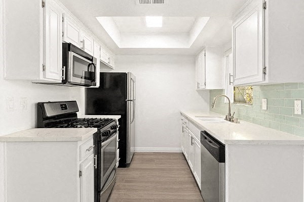 a white kitchen with a stove and a refrigerator