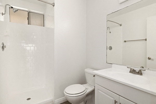 a white bathroom with a toilet and a sink
