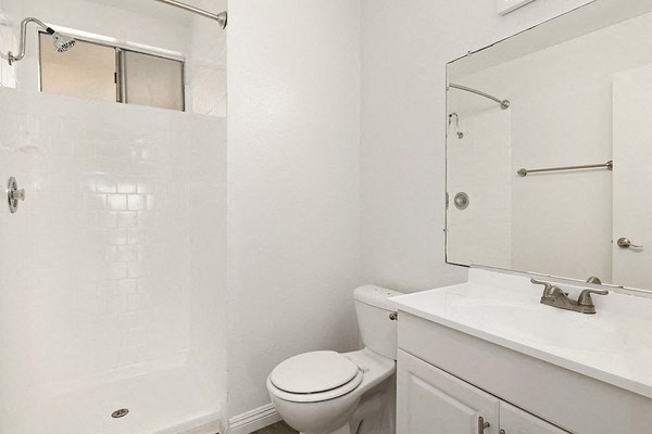 a white bathroom with a toilet and a sink