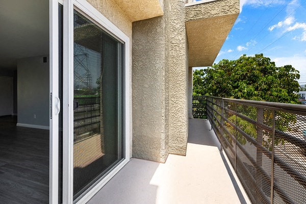a balcony with a glass door and a wooden railing