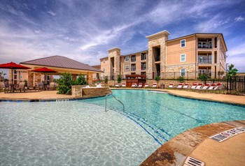 Pool with a row of lounge chairs and water feature - Photo Gallery 3