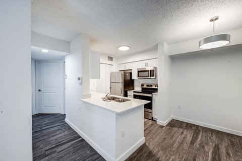A kitchen with a white island and stainless steel appliances.