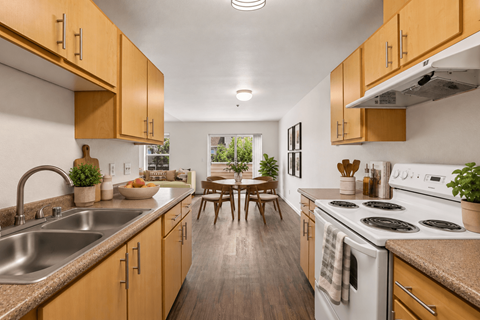A kitchen with wooden cabinets and a white stove top oven.