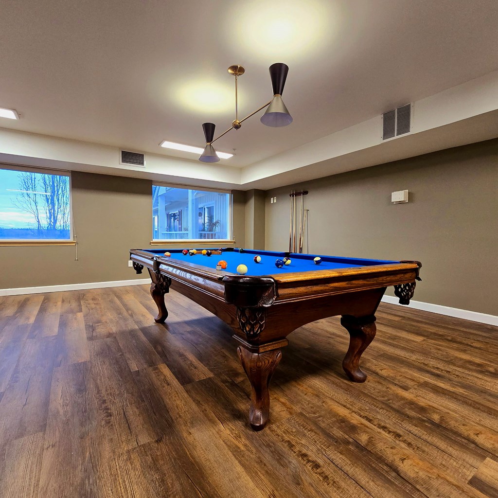 A pool table in a room with wooden flooring and a light fixture A pool table in a room with wooden flooring and a light fixture t Everett Senior Community, Everett, 98201