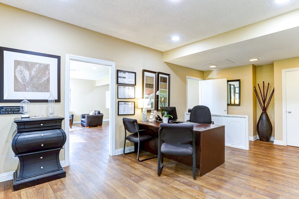 a living room with a desk and chairs and a fireplace