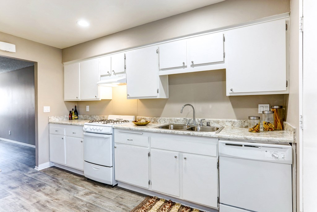 a kitchen with white cabinets and a sink and a counter top