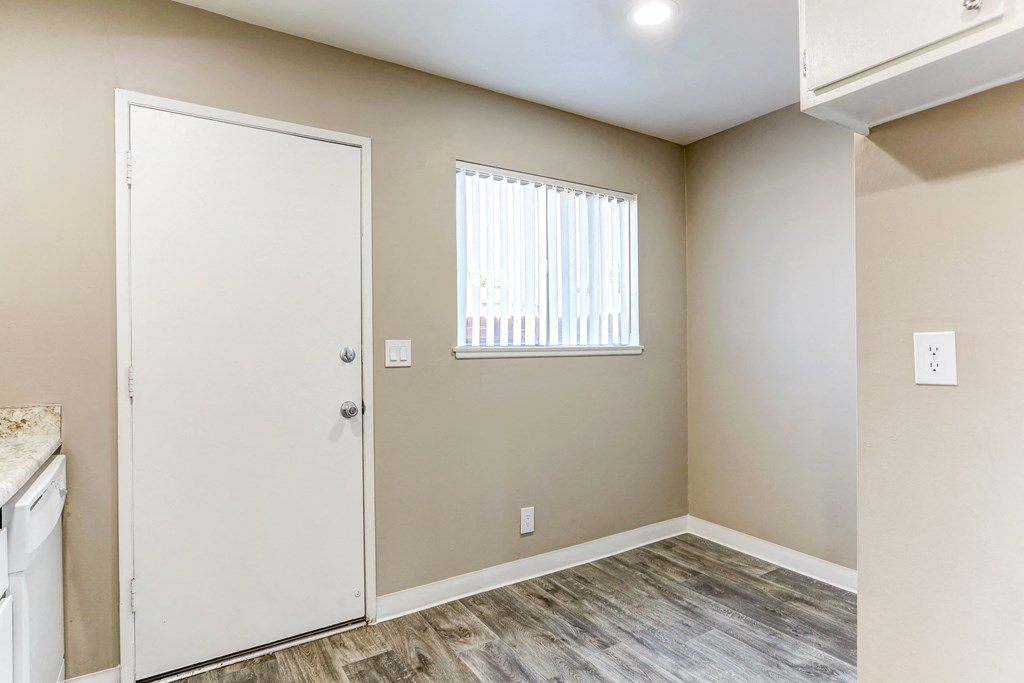an empty room with a white door and a window