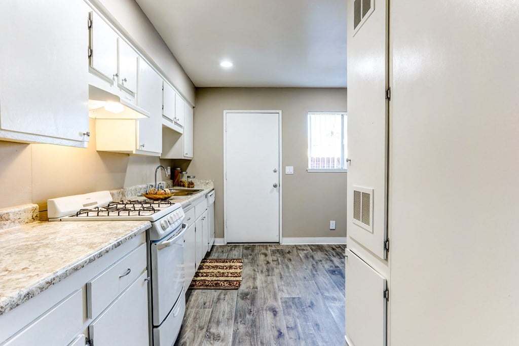 a kitchen with white cabinets and a stove and a refrigerator