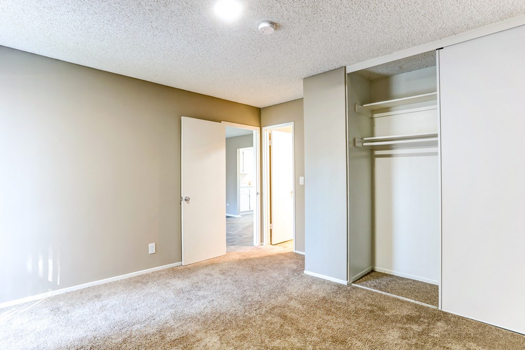 an empty room with a closet and a mirrored closet door