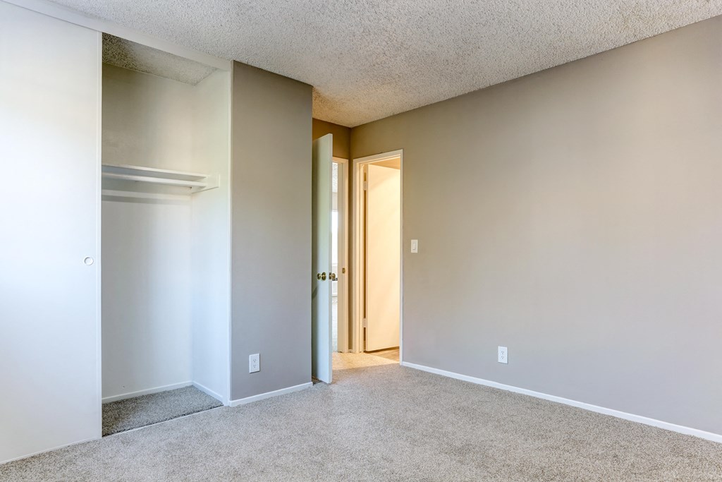 an empty living room with a door to a hallway