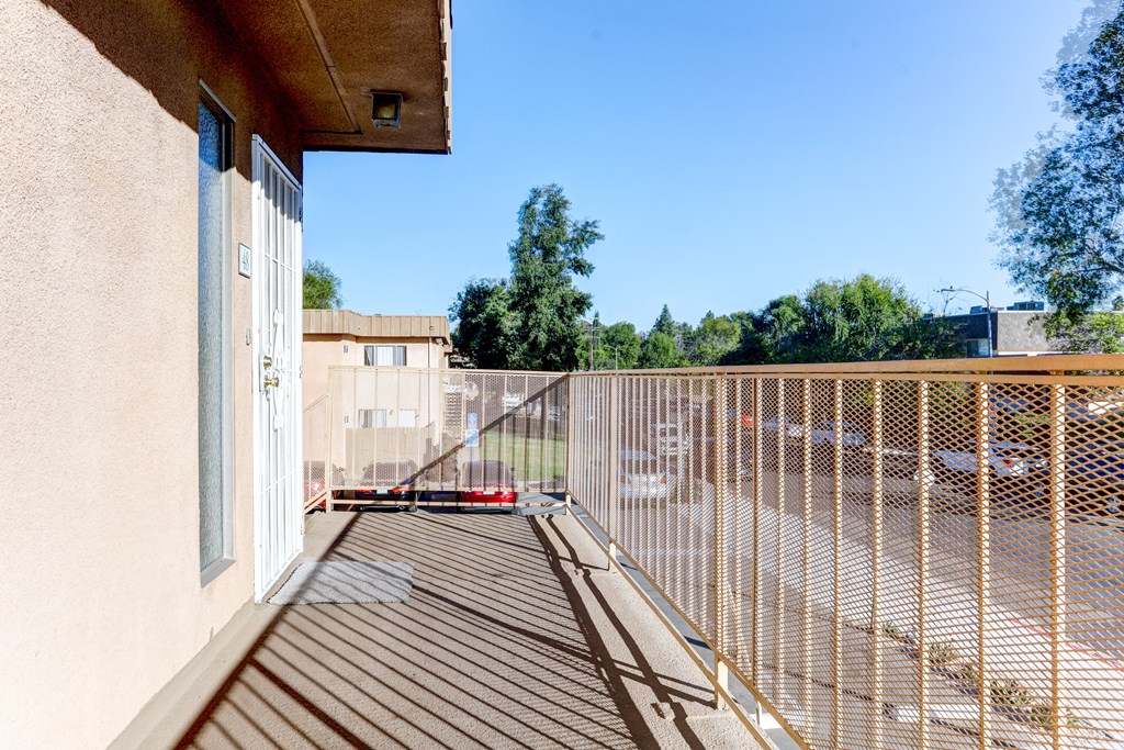 a balcony with a wooden deck and a fence