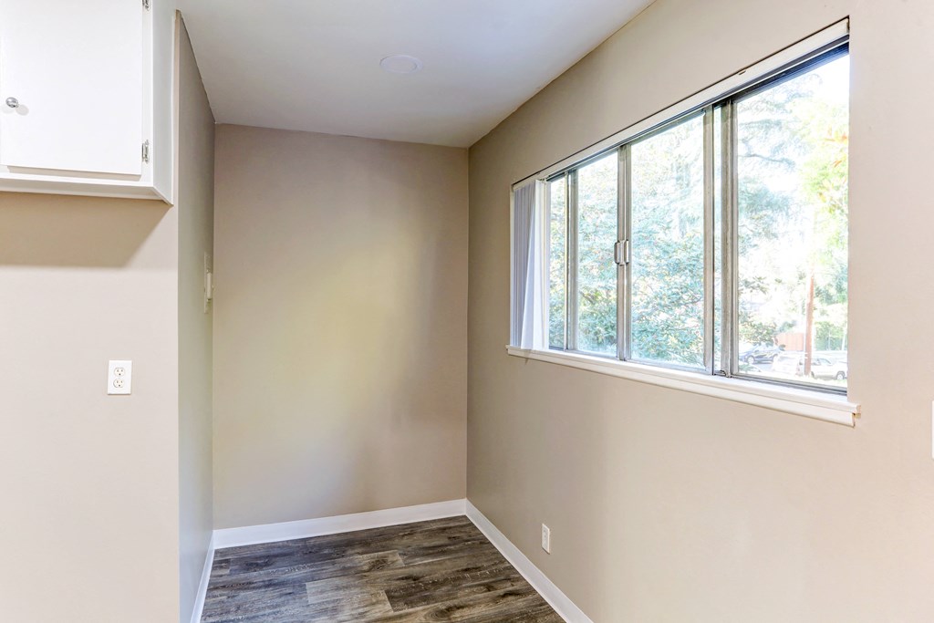 an empty room with a large window and a wooden floor