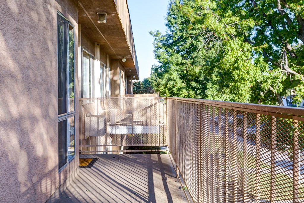 the balcony has a view of the trees and the house