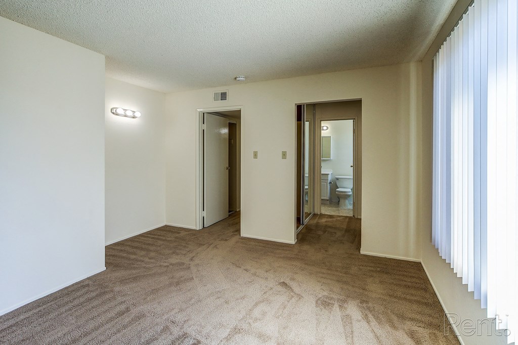a living room with white walls and a brown carpet