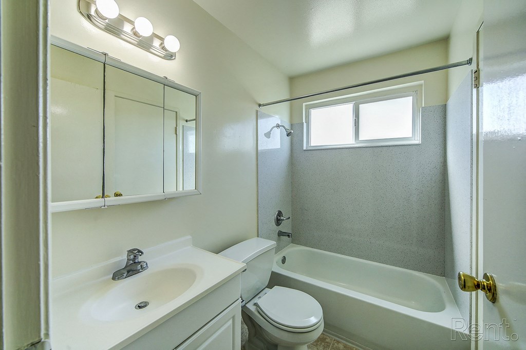 a bathroom with a white sink and toilet next to a white bathtub with a shower curtain