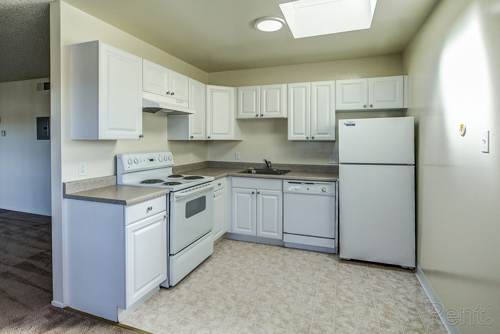 a kitchen with white cabinets and white appliances