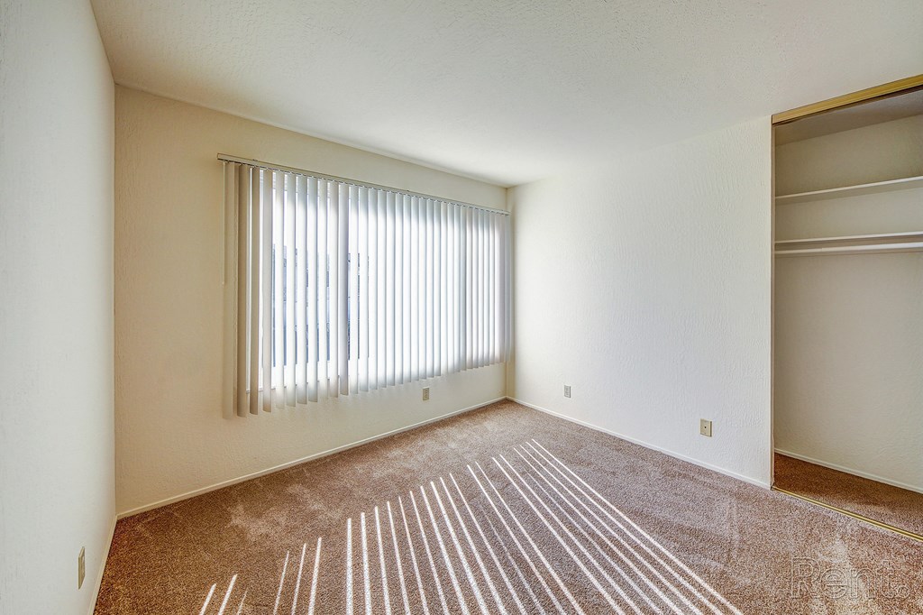 a bedroom with a large window and a closet