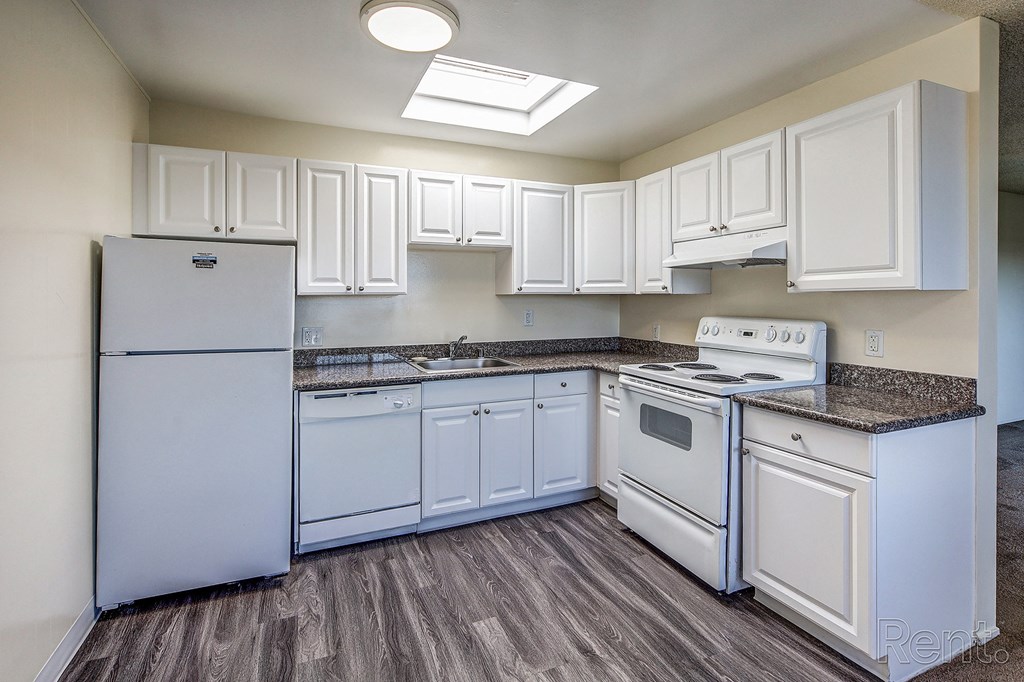 a kitchen with white cabinets and white appliances