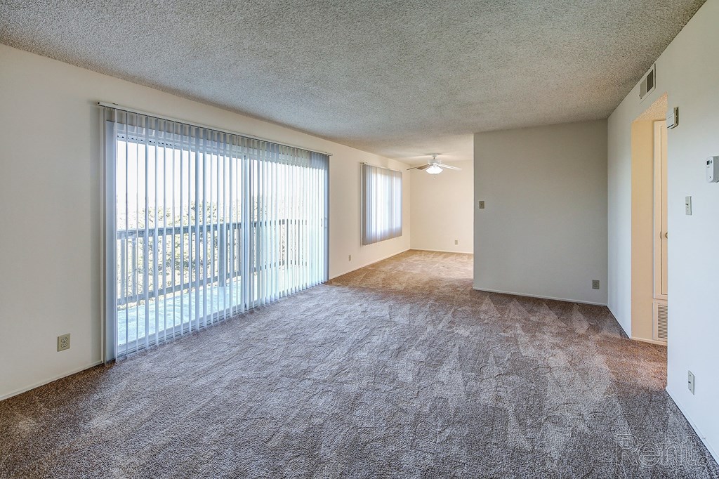 an empty living room with a sliding glass door