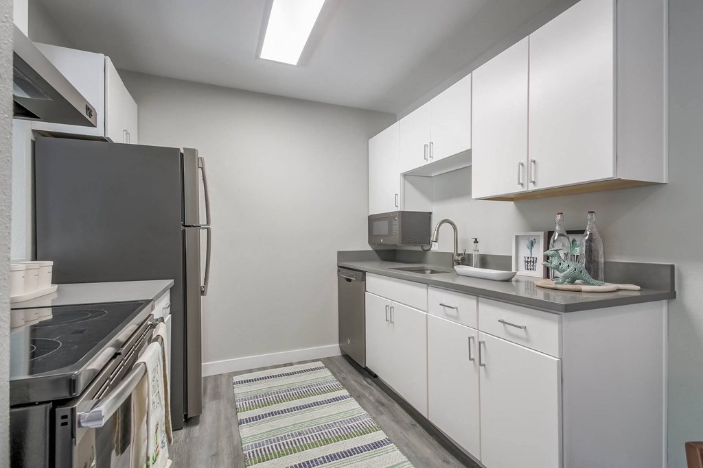 a kitchen with white cabinets and a stainless steel refrigerator at Park Capitol, Salt Lake City