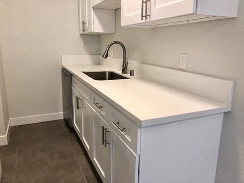 a kitchen with a sink and white cabinets