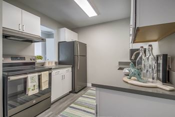 a kitchen with white cabinets and a stainless steel refrigerator at Park Capitol, Salt Lake City