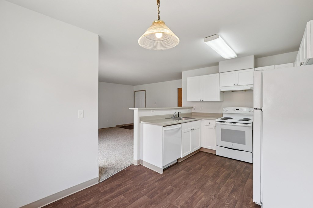 A kitchen with white cabinets and a white stove.at The Timbers by Vintage, Arlington, 98223