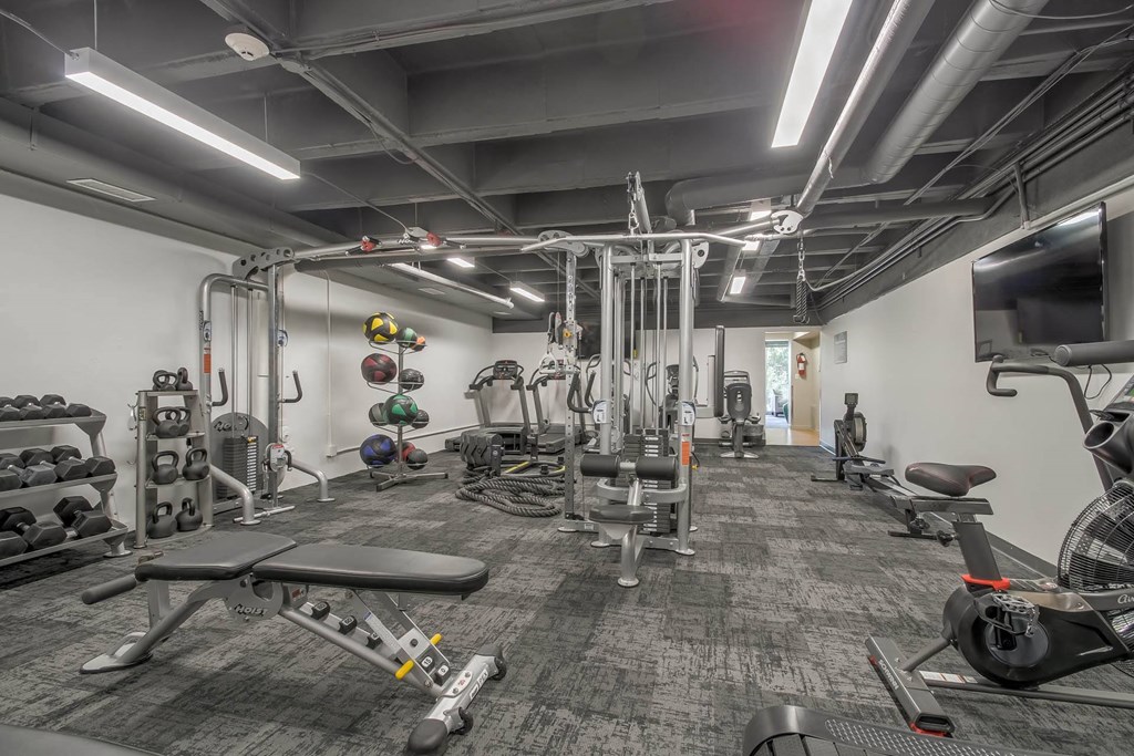 a gym with weights and cardio equipment and a tv at Park Capitol, Salt Lake City, UT 84103