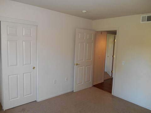 a bedroom with two closets and a door to a hallway