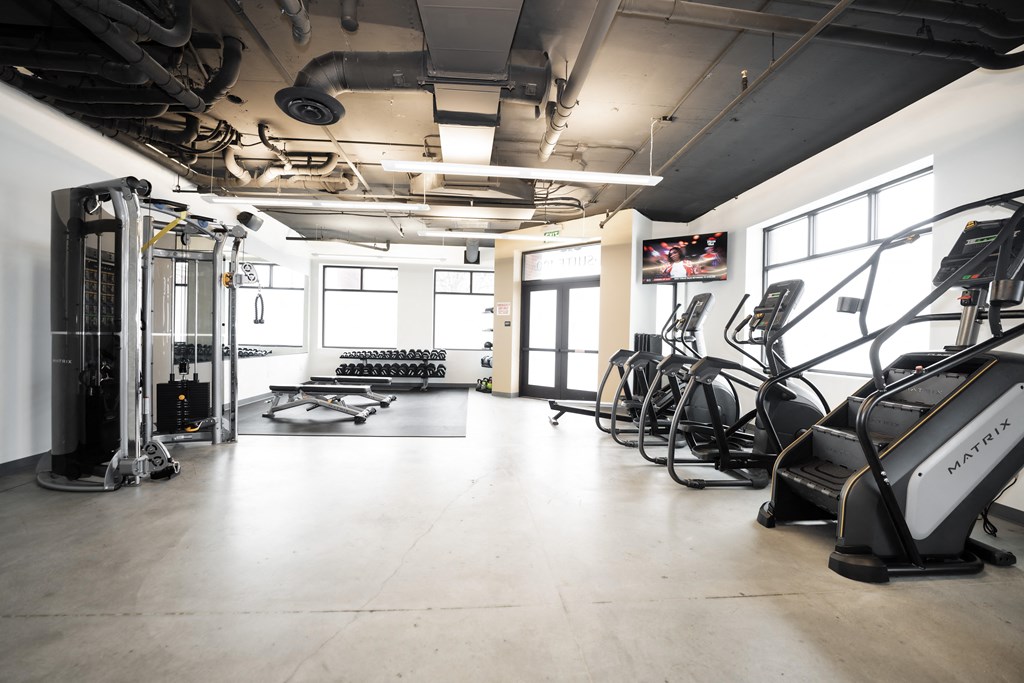 a fitness room with cardio equipment and weights