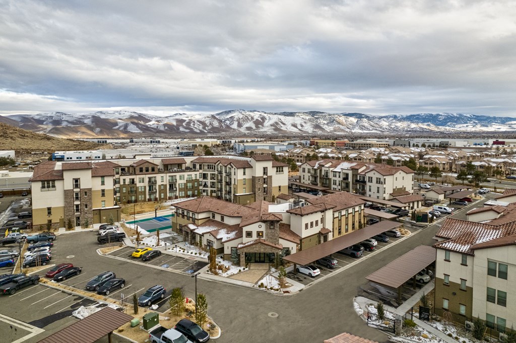 A large building complex with a parking lot in front of it.
