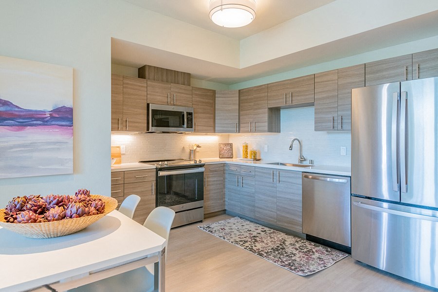 Apartments For Rent In San Rafael, CA - Kitchen With Stainless Steel Appliances, Corian Counters, Glass Tile Backsplash, Stunning Kitchen Cabinetry, Wood-Grain Style Flooring, Dishwasher, And A Built-In Microwave.