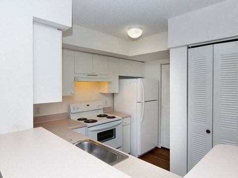 a kitchen with white appliances and white cabinets