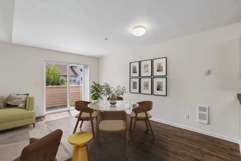 A dining room with a table set for four and a couch with a pillow.