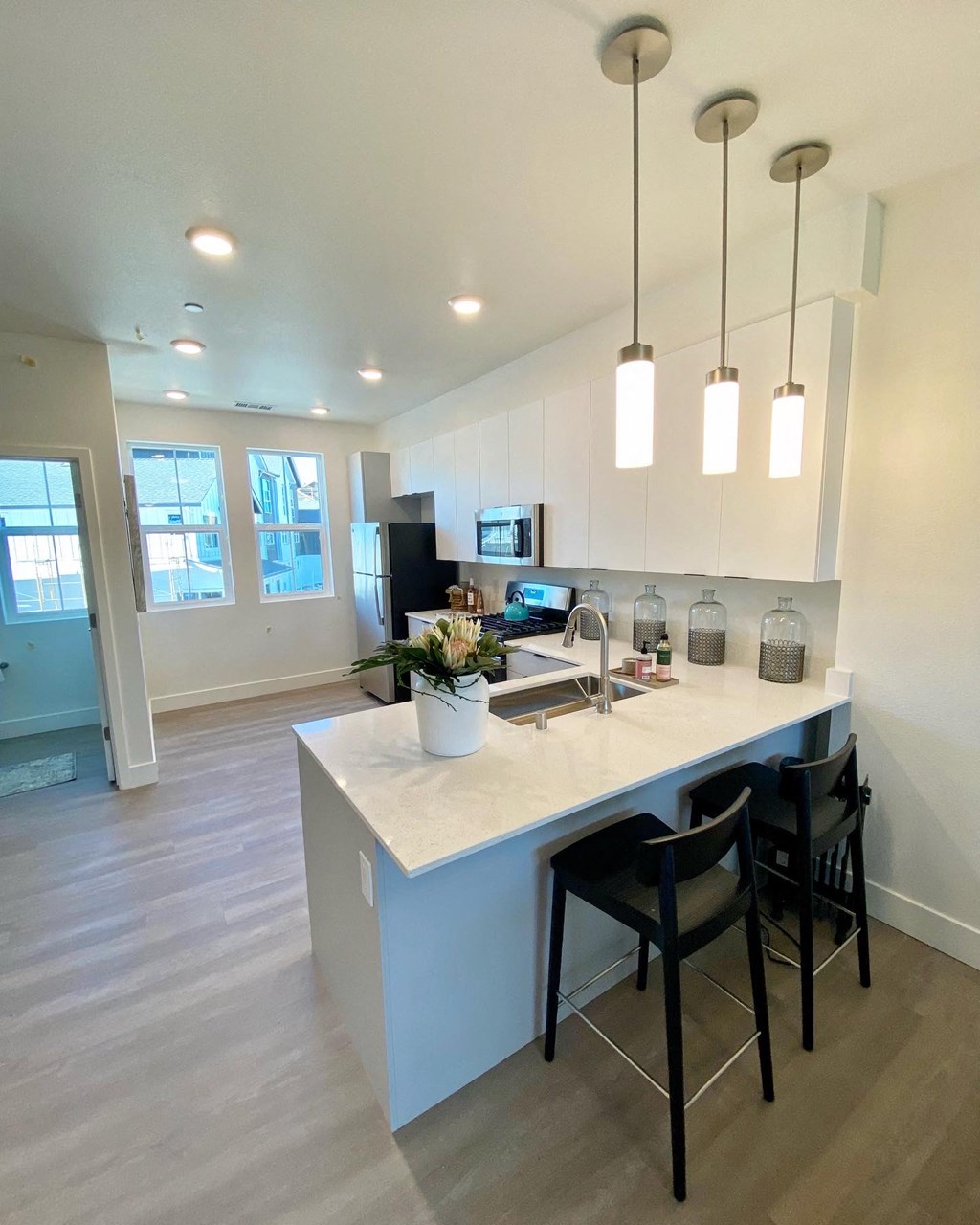 an open kitchen with an island and black stools