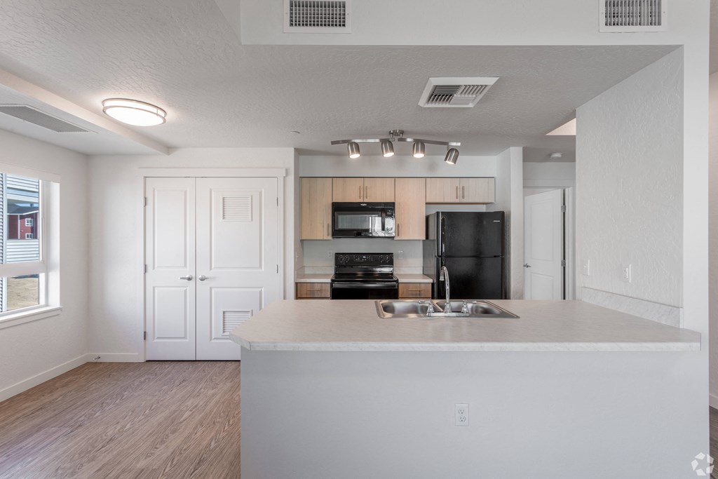 an empty kitchen with a counter top and a sink
