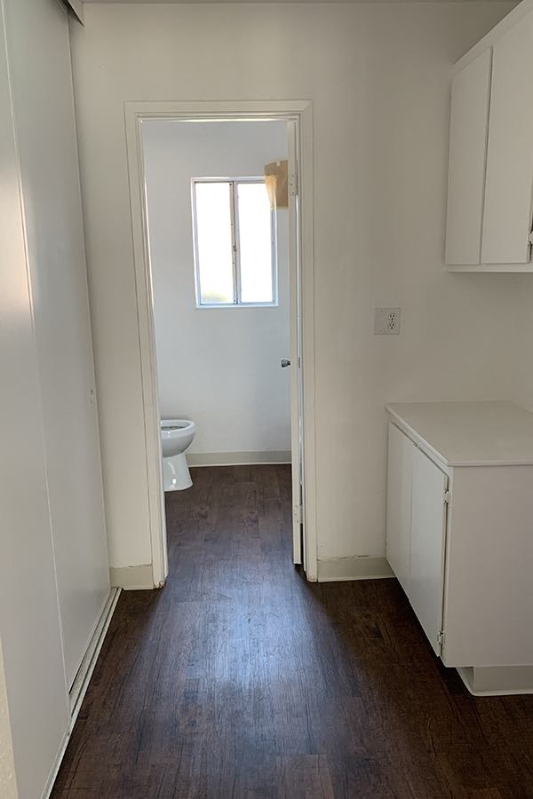 Hallway to bathroom with wood flooring