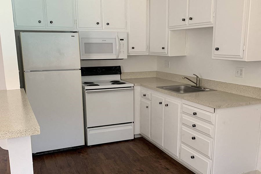 Renovated kitchen with white cabinets and appliances